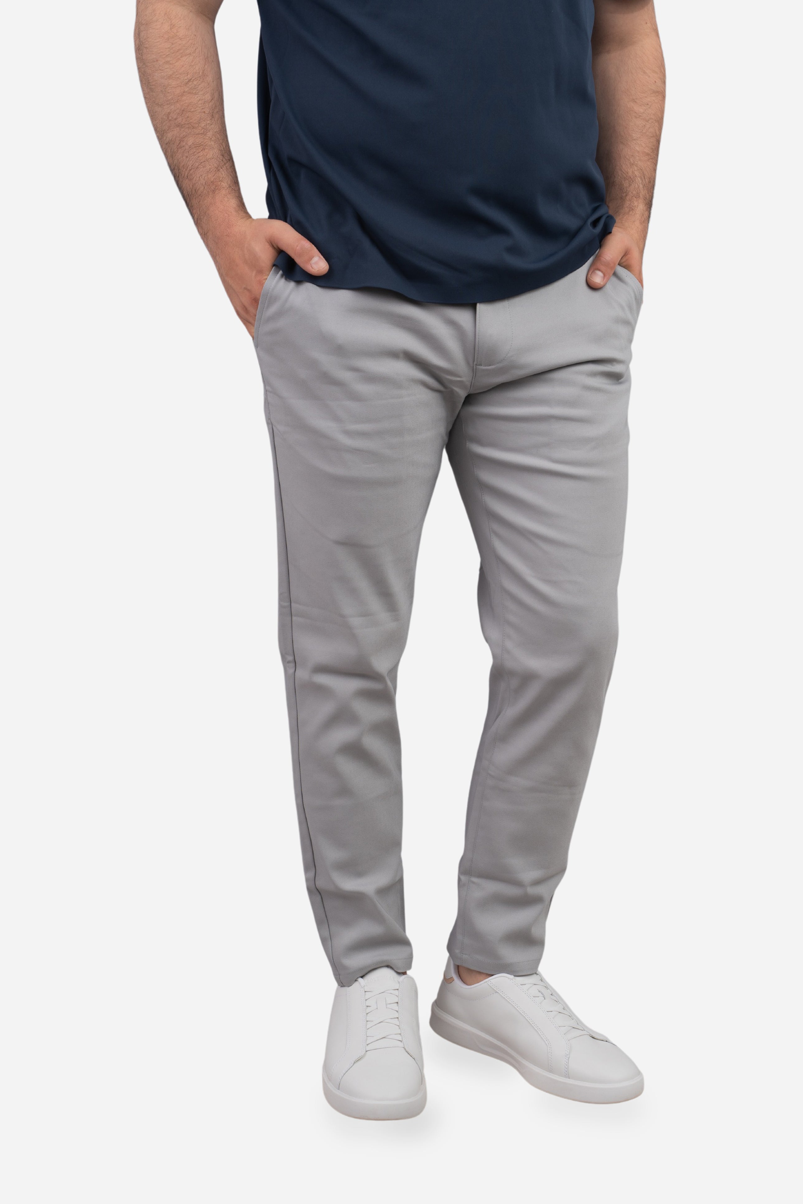 Person wearing gray pants and a navy shirt on a white background